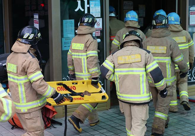 19일 오후 전남 화순군 화순읍 한 요양병원 지하에서 화재가 발생해 소방대원들이 부상자를 옮기기 위해 들것을 들고 이동하고 있다. 연합뉴스