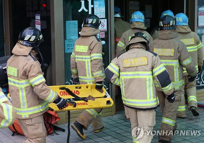 전남 화순서 요양병원 화재 발생 (화순=연합뉴스) 정회성 기자 = 19일 오후 전남 화순군 화순읍 한 요양병원 지하에서 화재가 발생해 소방대원들이 부상자를 옮기기 위해 들것을 들고 이동하고 있다. 2023.4.19 hs@yna.co.kr