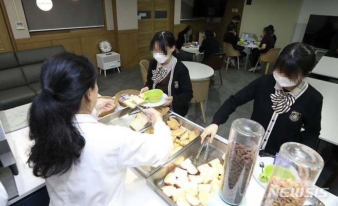 [서울=뉴시스] 최진석 기자 =지난 20일 조식 시범 운영학교인 서울 도봉구 정의여자고등학교에서 학생들이 배식받고 있다. 서울시교육청은 기숙사가 없는 일반학교에서도 수요가 있는 경우 아침밥을 제공하는 '조식 시범 운영학교'를 운영하고 있다 2023.04.22. myjs@newsis.com