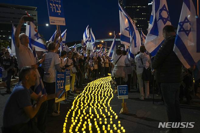 [텔아비브( 이스라엘)= AP/뉴시스] 이스라엘 건국 25주년 기념일인 25일을 앞두고 토요일인 22일 저녁 (현지시간)  텔 아비브 시내에서 촛불을 켜놓은 시위대가 네타냐후 총리의 사법개혁안 폐기를 요구하고 있다.