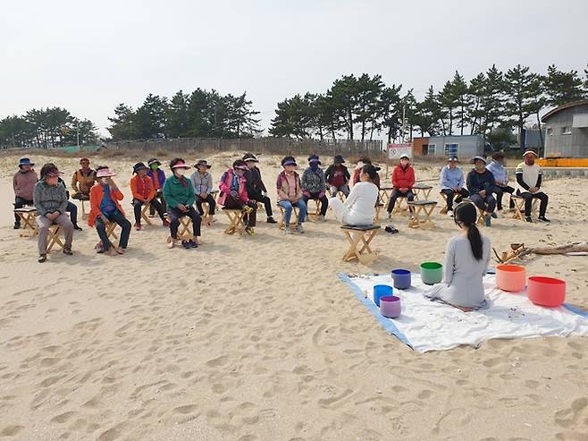 해양치유 힐링 프로그램 참가자들이 해변 명상을 하고 있다. [사진제공=완도군]