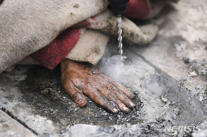 [베를린=AP/뉴시스]독일 수도 베를린에서 24일 정부의 기후 정책에 반대하기 위해 강력 접착제로 자신의 몸을 도로에 붙여 교통 흐름 차단에 나선 기후단체 회원의 손이 붙어 있는 도로를 독일 경찰이 굴착기를 이용해 뜯어내려 하고 있다. 독일 기후 운동가들이 이날 아침 수도 베를린에서 강력 접착제로 자신들의 몸을 도로에 붙임으로써 수도 전체의 교통을 마비시키려 했다. 2023.04.24.