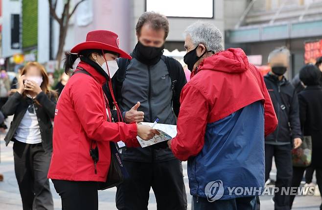 리오프닝에 돌아오는 외국인 관광객들 (서울=연합뉴스) 김인철 기자 = 리오프닝(경제활동 재개) 분위기에 홍대나 명동 지역 호텔의 외국인 투숙객 비중이 늘어나고 있는 가운데 19일 오후 서울 중구 명동에서 관광안내 직원들이 외국인 관광객들에게 길을 알려주고 있다. 2022.10.19 yatoya@yna.co.kr