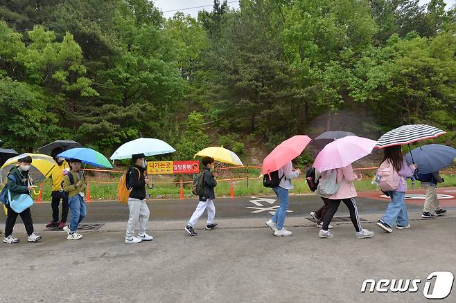 봄비가 내린 지난 25일 오전 경북 포항시 북구에 있는 초등학교 인근에서 우산을 쓴 학생들이 줄을 맞춰 걸어가고 있다.2023.4.25/뉴스1 ⓒ News1 최창호 기자