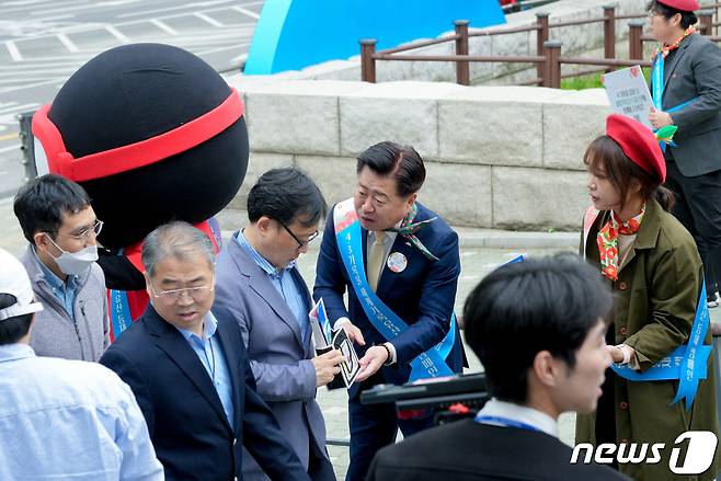 오영훈 제주지사가 26일 서울 여의도공원에서 한 서울시민에게  '4·3기록물 세계기록유산 등재' 홍보물을 전해주고 있다.(제주도 제공)/뉴스1