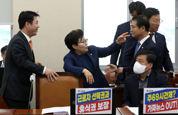 지난 25일 국회에서 열린 환경노동위원회 전체회의에서 국민의힘 간사인 임이자 의원(가운데)과 지성호(왼쪽) 의원 등과 대화하는 가운데 이정식 고용노동부 장관(오른쪽)이 인사하기 위해 이동하고 있다. [사진=뉴시스]