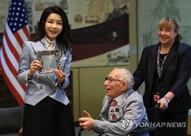 참전용사에게 선물받은 김건희 여사 (워싱턴=연합뉴스) 진성철 기자 = 미국을 국빈 방문한 윤석열 대통령의 부인 김건희 여사가 25일(현지시간) 워싱턴DC 미 보훈요양원에서 한국전 참전용사인 마빈 플로드 씨가 제작한 유리세공 접시를 선물받고 있다.   2023.4.26 [공동취재] zjin@yna.co.kr