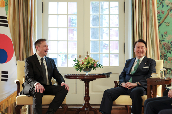 President Yoon Suk Yeol, right, chats with Tesla CEO Elon Musk during their meeting at Blair House in Washington on Wednesday. [JOINT PRESS CORPS]