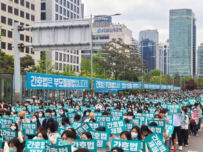 대한간호협회와 간호법제정추진범국민운동본부 회원들이 26일 서울 영등포구 국회의사당 앞 도로에서 ‘간호법 국회 통과 촉구 수요한마당’ 집회를 열고 국회 간호법 통과를 촉구하고 있다.   대한간호협회