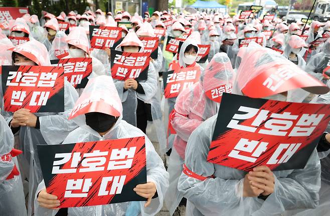 25일 오후 서울 여의도 국회 앞에서 열린 간호법 저지 전국간호조무사 대표자 연가투쟁에서 참가자들이 피켓을 들고 있다. 대한간호조무사협회와 대한의사협회 등 13개 단체는 오는 27일 간호법 제정안이 국회 본회의를 통과할 경우 총 파업에 나설 방침이다. [연합]