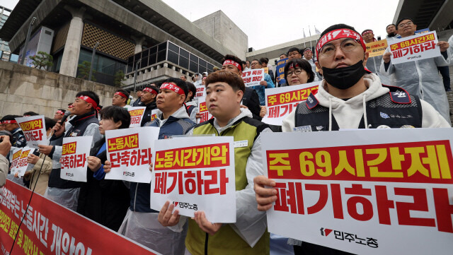 전국민주노동조합총연맹 조합원들이 지난 18일 오전 서울 종로구 세종문화회관 계단에서 정부의 노동시간 제도 개편안을 규탄하며 손팻말을 들고 있다. 이들은 기자회견을 마친 뒤 정부에 국민 의견서를 제출했다. 김경호 선임기자 jijae@hani.co.kr