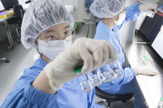 SK bioscience researchers check SKYCovione Covid-19 vaccine vials at L House, the company’s vaccine manufacturing facility in Andong, North Gyeongsang. [SK BIOSCIENCE]