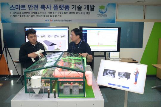 ETRI 연구진이 스마트 축사의 공기 재순환 시스템에 대해 논의하고 있다. 사진=한국전자통신연구원 제공