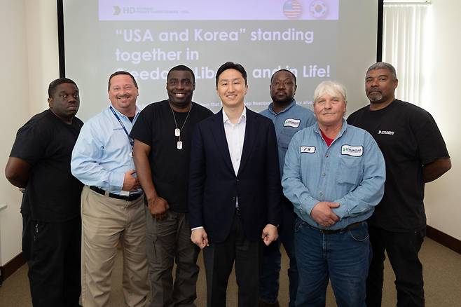 정기선(가운데) HD현대 사장이 최근 미국 앨라배마주 몽고메리시에 위치한 HD현대일렉트릭 변압기 공장에서 참전용사를 가족으로 둔 직원들을 만나 기념촬영을 하고 있다. [HD현대 제공]