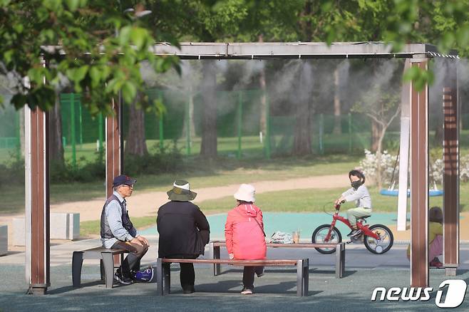 대구의 낮 최고기온이 29.4도까지 오른 지난달 20일 오후 대구 수성구 고모동 수성패밀리파크를 찾은 시민들이 쿨링포그(안개형 냉각 시스템)가 작동된 벤치에서 초여름 더위를 식히고 있다. /사진=뉴스1