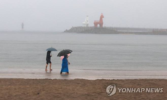 비 내리는 제주 바닷가 (제주=연합뉴스) 박지호 기자 = 제주도에 호우특보가 내려진 4일 오전 제주시 이호해수욕장에서 우산을 든 이들이 걷고 있다. 2023.5.4 jihopark@yna.co.kr