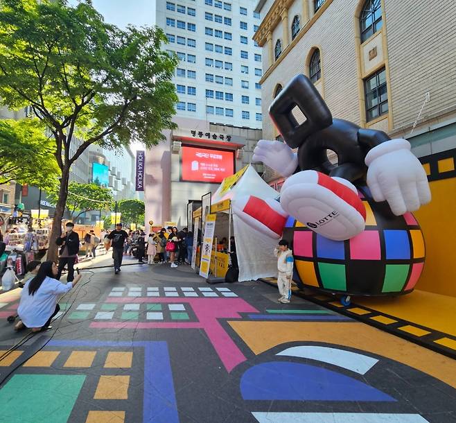 A kid poses in front of the Myeongdong character "Mieungi" at Myeongdong Festival 202" on Monday. (Park Yuna/The Korea Herald)