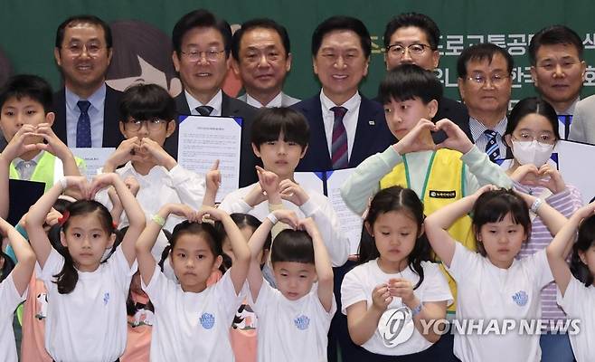 여야대표와 어린이들 (서울=연합뉴스) 한상균 기자 = 국민의힘 김기현 대표와 민주당 이재명 대표가 4일 국회에서 열린 어린이 안전 헌장 선포식에서 어린이들과 기념촬영을 하고 있다. 2023.5.4 xyz@yna.co.kr