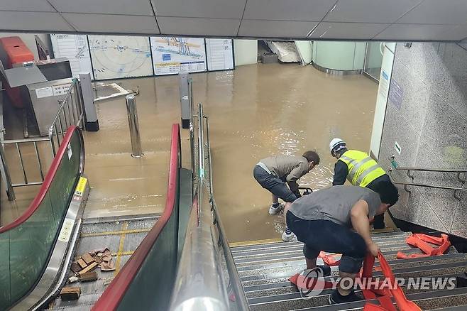 폭우에 침수된 광주 지하철 공항역 (광주=연합뉴스) 정회성 기자 = 5월 5일 광주 지하철 1호선 공항역 내부가 폭우에 침수돼 광주도시철도공사 관계자가 배수 작업을 하고 있다. hs@yna.co.kr