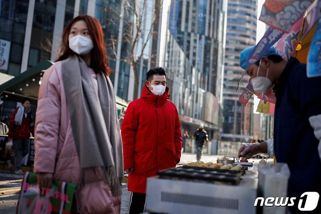 지난 1월 중국 베이징의 쇼핑 지구에서 주민이 노점 음식을 사고 있다. 2023.01.03. ⓒ 로이터=뉴스1 ⓒ News1 우동명 기자