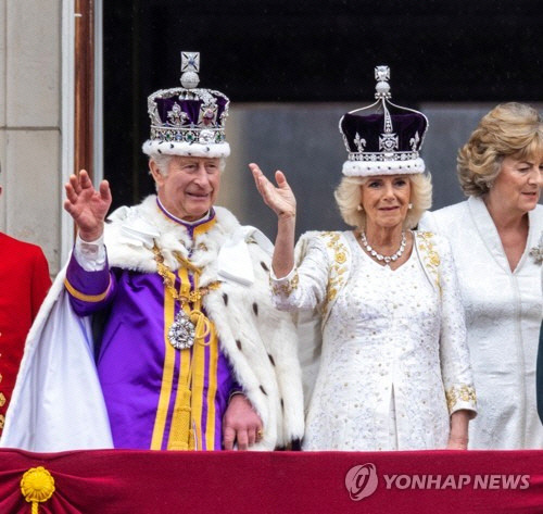 찰스 3세 영국 국왕의 대관식이 열린 6일(현지시간) 찰스 국왕과 커밀라 왕비가 버킹엄궁전에서 손을 흔들고 있다. [런던 AP=연합뉴스]