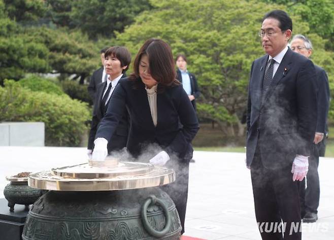 7일 오후 서울 동작구 국립서울현충원에서 방한 일정을 시작한 기시다 후미오(오른쪽) 일본 총리가 기시다 유코 여사가 분향하는 모습을 지켜보고 있다 . 