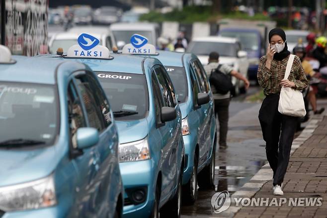 인도네시아 자카르타 거리 인도네시아 수도 자카르타의 도심에서 한 여성이 정차된 택시 옆을 걷고 있다.
[EPA 연합뉴스 자료사진. 재판매 및 DB 금지]