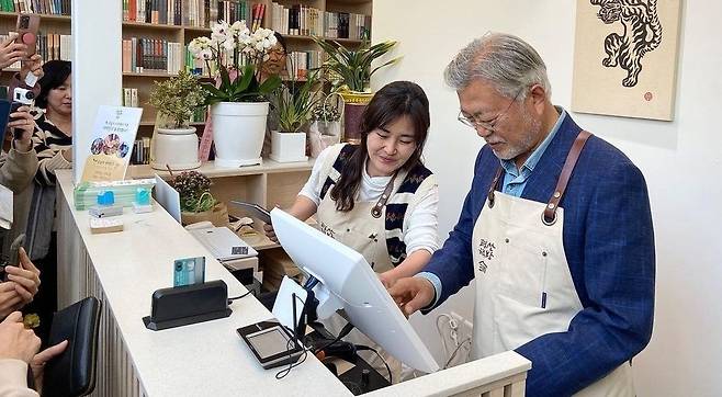 평산책방 오픈 첫날인 지난달 26일 문재인 전 대통령이 계산대에서 업무를 보고 있다. /뉴스1