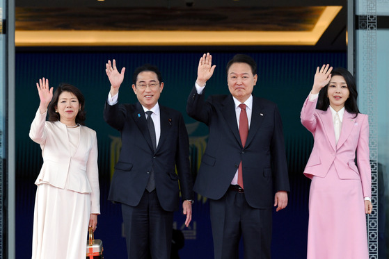 Korean President Yoon Suk Yeol, center right, and first lady Kim Keon-hee, wave with Japanese Prime Minister Fumio Kishida, center left, and first lady Yuko Kishida in a welcoming ceremony at the Yongsan presidential office in central Seoul Sunday ahead of their bilateral summit. [JOINT PRESS CORPS]