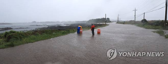 빗물에 잠긴 도로 (서귀포=연합뉴스) 박지호 기자 = 제주도 전역에 폭우가 쏟아진 4일 오후 제주 서귀포시 대정읍 상모리의 해안도로가 침수돼 차량 통행이 일부 통제되고 있다. 2023.5.4 jihopark@yna.co.kr