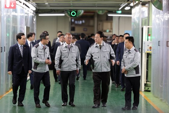 윤석열 대통령이 지난달 11일 경기도 화성 기아 전기차 전용공장 기공식에 앞서 정의선 현대자동차그룹 회장(윤 대통령 왼쪽) 등과 생산 라인을 둘러보고 있다. 연합뉴스