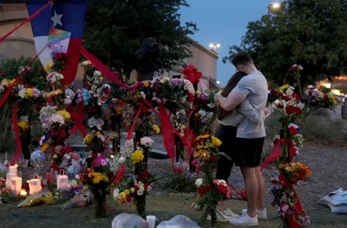 People mourn in a memorial space set up in front of the Allen outlet mall in Texas where eight people died in a mass shooting. Getty Images / AFP-Yonhap News