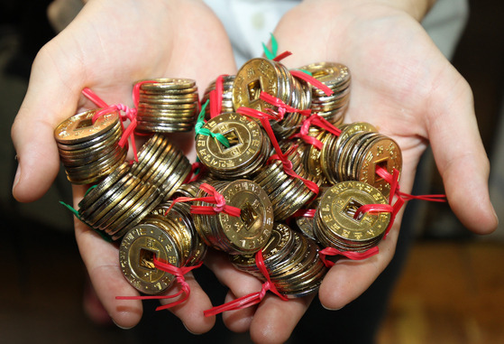 Yeopjeon or brass coins are used to buy food at Tongin Traditional Market in Jongno District, central Seoul [JOONGANG ILBO]