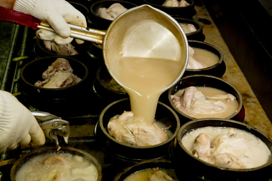 A cook at Tosokchon Samgyetang in Jongno District, central Seoul, makes Korean chicken ginseng soup known as samgyetang. [JOONGANG ILBO]