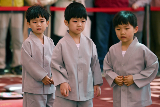 9일 서울 종로구 조계사 대웅전 앞마당에서 열린 동자승 단기출가 보리수 새싹학교 삭발 수계식에서 동자승들이 입장하고 있다. 백동현 기자