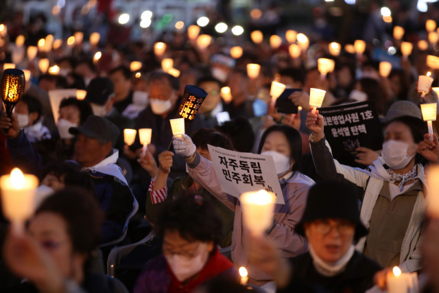 ▲1일 오후 광주 5·18민주광장에서 열린 천주교정의구현전국사제단의 친일매국 검찰독재 윤석열 퇴진과 주권회복을 위한 월요 시국미사에서 시민들이 손팻말과 촛불을 들고 있다. ⓒ연합뉴스