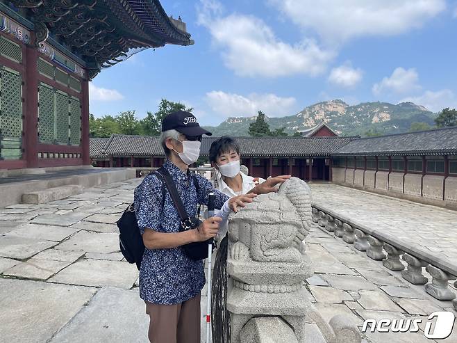 서울관광재단 현장영상해설사의 해설을 들으며 해치를 만져보는 시각장애인 관람객(서울관광재단 제공)