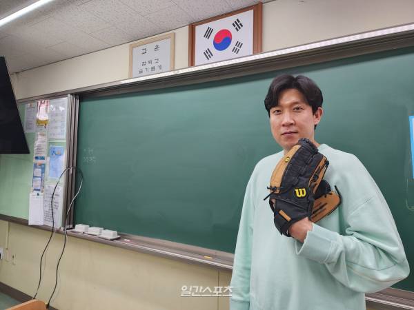 22년 동안 누비던 그라운드를 뒤로하고 교단에 선 윤정우. 자신의 경험이 학생들에게 도움이 될 수 있다는 사명감으로 하루하루를 보내고 있다. 사진은 윤정우가 지난달 갈뫼중학교 한 교실에서 글러브를 끼고 포즈를 취한 모습. 안희수 기자&nbsp;