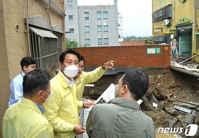 오세훈 서울시장이 지난해 8월 9일 서울 양천구 신월7동에서 전날 내린 폭우로 도로 침하가 발생한 현장을 점검하고 있다. (서울시 제공)