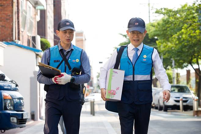 이종호 과학기술정보통신부 장관이 11일 서울 서대문구 북가좌동 인근에서 임익수 서대문우체국 집배팀장과 함께 복지등기우편서비스를 점검하고 있다. /과기정통부 제공