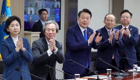 3년 4개월만에 코로나19 위기 단계가 '경계'로 하향조정됐다. 윤석열 대통령과 중대본 위원들은 11일 코로나19 중대본 회의에 앞서 현장에서 활약한 보건 의료진에게 격려의 박수를 보냈다./뉴시스