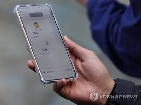 토스는 앱을 실행하면 주변에 앱을 켠 사용자의 아이콘이 뜨고, 이를 누르면 1명당 10원씩 적립해 주는 앱테크 서비스를 제공하고 있다. 한 시민이 '함께 토스 켜고 포인트받기'를 이용하고 있는 모습. 연합뉴스