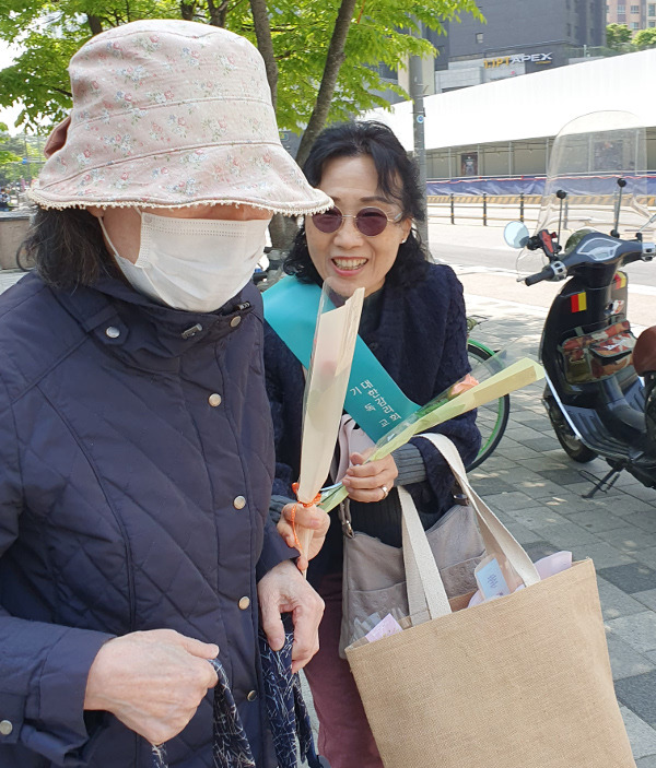 박계분(오른쪽) 서울 일신교회 권사가 이달 초 감리회 웨슬리전도학교가 주최한 ‘전도꾼 만들기’ 교육을 받은 뒤 노방전도를 하면서 행인에게 꽃을 선물하고 있다.