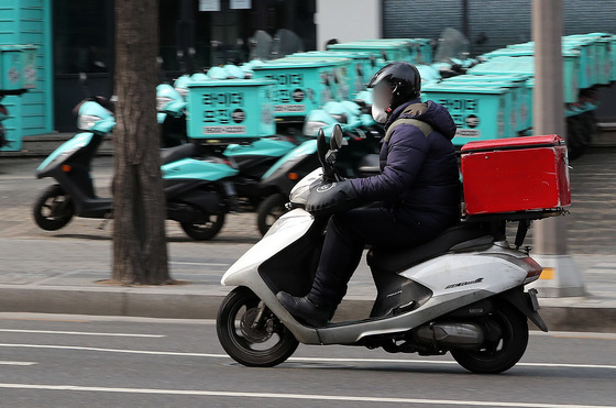 지난해 2월 21일 서울 강남구 배민라이더스 남부센터에 배달용 오토바이 앞으로 한 배당 노동자가 지나가고 있다.   /사진=뉴스1