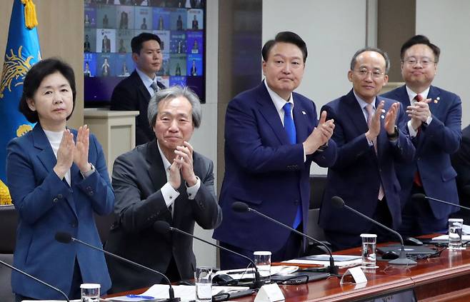 윤석열 대통령과 중대본 위원들이 11일 서울 용산 대통령실 청사에서 열린 코로나19 중앙재난안전대책본부 회의에서 코로나19 방역 최전선에서 활약한 의사, 간호사, 간호조무사 등 보건의료진에게 격려의 박수를 보내고 있다. [연합]