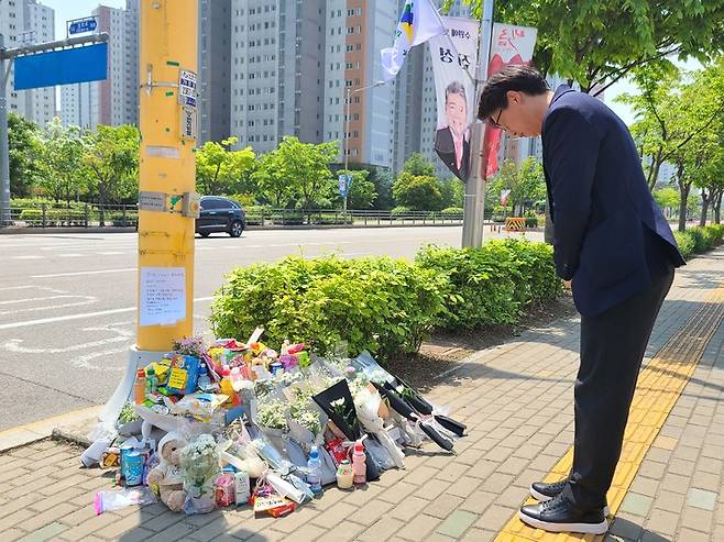 [수원=뉴시스] 양효원 기자 = 경기 수원시 권선구 호매실동 한 사거리에서 신호 위반 버스에 치어 사망한 초등학생을 위해 마련된 추모공간을 찾은 시민이 묵념하고 있다. 2023.5.11. hyo@newsis.com *재판매 및 DB 금지