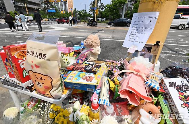 [수원=뉴시스] 김종택 기자 = 11일 경기도 수원시 권선구의 한 사거리에 전날 어리이보호구역(스쿨존)에서 시내버스에 치여 숨진 초등학생을 추모하는 추모 물품들이 놓여 있다. 2023.05.11. jtk@newsis.com