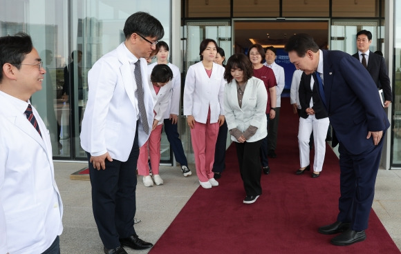 고개 숙여 의료진 배웅하는 尹 - 코로나19 중앙재난안전대책본부 회의를 마친 윤석열 대통령이 11일 용산 대통령실 청사 현관 밖까지 나가 코로나19 최전선에서 활약한 보건 의료진에게 고개 숙여 인사하고 있다. 대통령실 제공