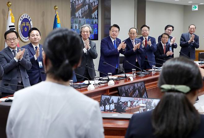 윤석열 대통령과 중대본 위원들이 11일 서울 용산 대통령실 청사에서 열린 코로나19 중앙재난안전대책본부 회의에 앞서 코로나19 방역 최전선에서 활약한 의사, 간호사, 간호조무사 등 보건 의료진에게 격려의 박수를 보내고 있다. /연합뉴스