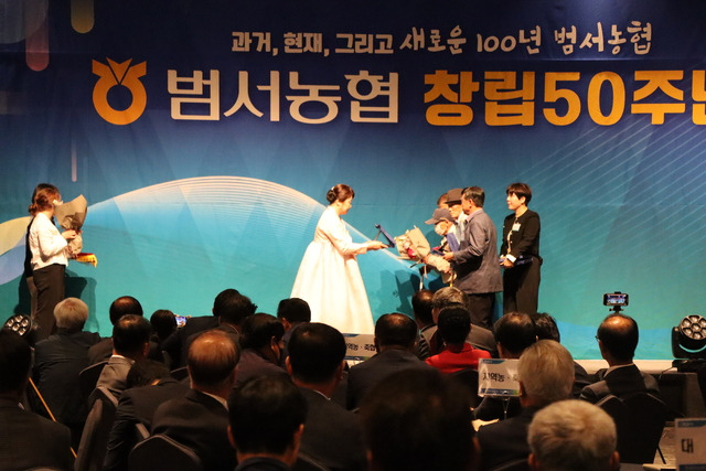 김숙희 울산 울주 범서농협 조합장(왼쪽)이 창립 50주년 기념식에서 창립 조합원들에게 공로패를 수여하고 있다.